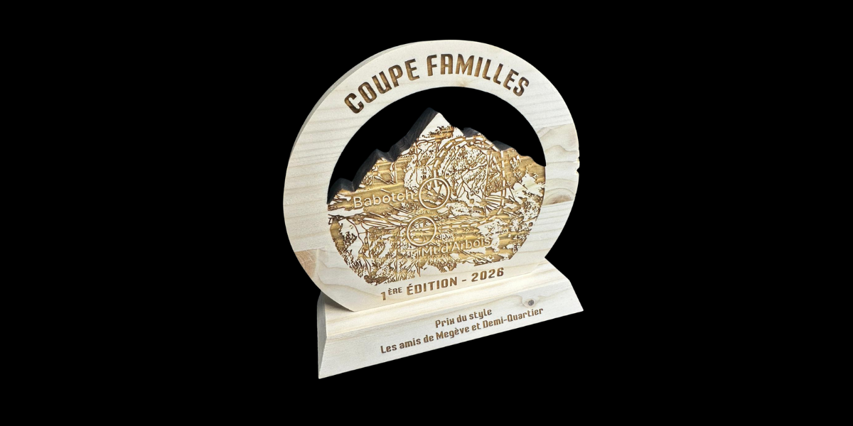 Trophée en bois clair gravé et découpé représentant un paysage de montagne, réalisé pour la Coupe Familles 2026 à Megève, avec socle personnalisé.