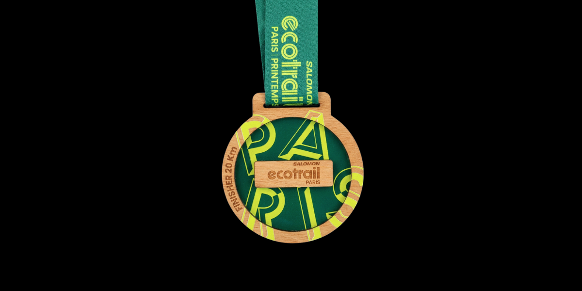 Médaille finisher EcoTrail Paris 2026 en bois massif PEFC avec impression verte et gravure laser, fabriquée en France.